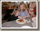 Brianna Hulme helping Karen Crapo -- just how much candy can you fit on one gingerbread man?