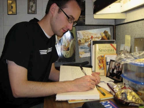 Writing in his journal at his desk.