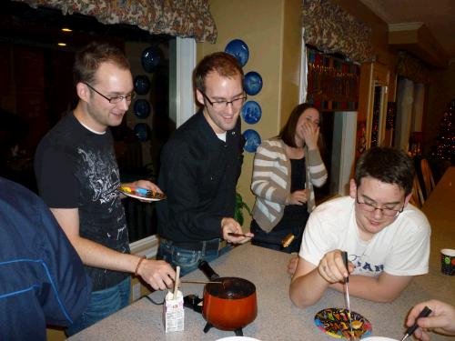 The rule is if you drop something in the fondue you have to kiss the person next to you.  Elliot kept avoiding standing by Grandpa :)