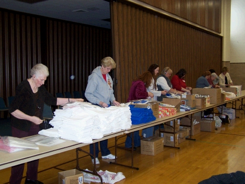 Ladies helping to assemble several hundred women's hygiene kits.