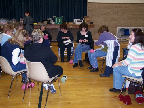 A bunch of ladies learning how to crochet granny squares that can then be made into afghans for hospice patients.