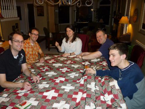 Gathered around the dining room table to tie a quilt for Haiti -- you just never know when those scout knots might come in handy!