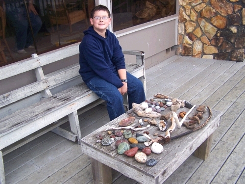 Clark showing off our collection of rocks, shells and driftwood.