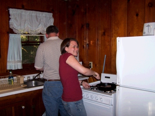 Tess browning sausage for pizza on our cute little gas stove. 