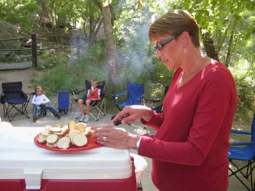 Melinda cutting up potatoes for their foil dinners.