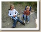 Karen and Jackson Crapo sitting on their little chairs that fold up to be backpacks they can carry themselves.