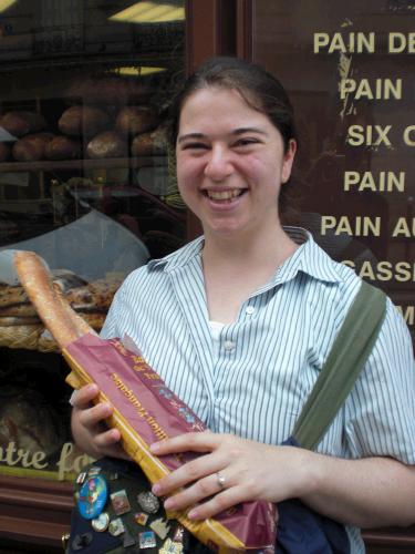 Anne happy to be buying bread at the market for dinner.