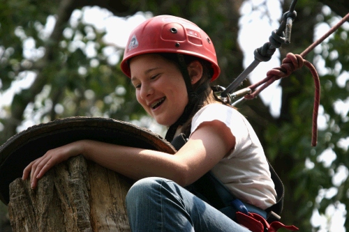 Madeleine climbing the eagle's perch at the ropes course. Once she reached the top, she had to stand on a really wobbly top and turn around. Then she had to jump off to catch a trapeze bar.