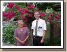 Elder Brown with Sister Trevio in front of beautiful Bougainvillea flowers.