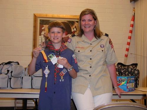 Elliot with his cub master, Stephanie Hogan.  He earned his Bear badge, gold and silver arrowpoints and received his colors for Webelos.