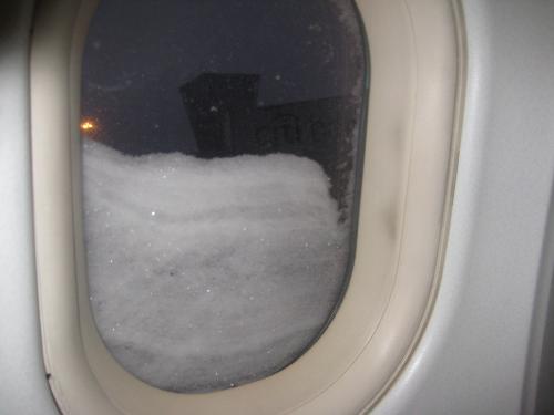 Tess on the plane heading to London, waiting for the plane to be deiced.