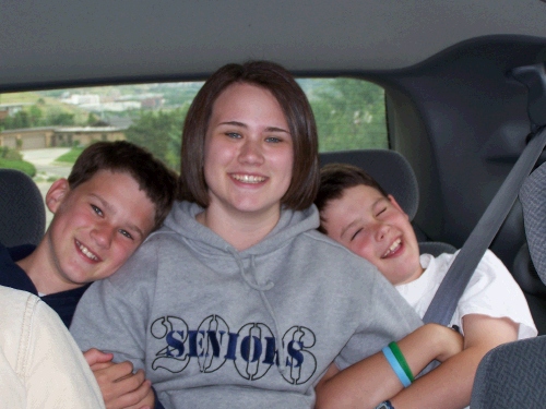 Tess just loves sitting in the back between her adorable little brothers -- yeah right.