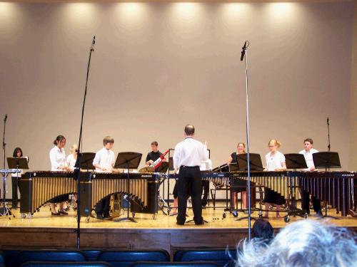 The whole percussion ensemble playing together.  Elliot is in the center back with the "keytar" and Clark is on the far right playing the marimba.