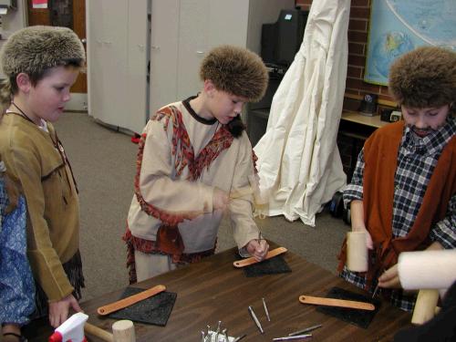 Elliot, dressed up like a mountain man, getting the experience of working with leather and tools.  I was a parent helper that day, helping 60 kids make bracelets.  I went home with a "pounding" headache!