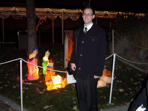 Elder Brown in front of the manger scene.  They did a great job at decorating with Christmas lights.