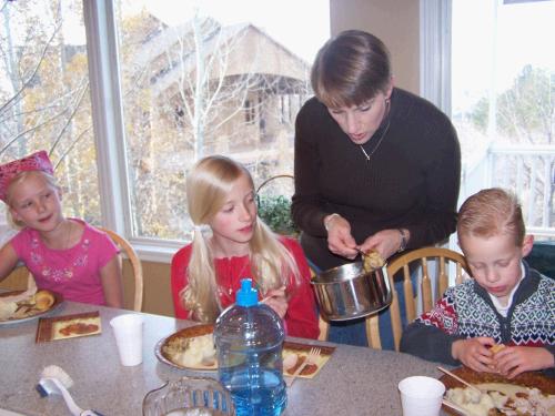 Melinda serving up stuffing to Marielle Hulme, Camilla and Andrew Israelsen.