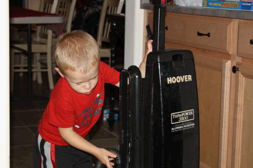 He looks like a total professional as he puts the hose where it goes, pulls the cord out across the room so that he can wind it up without getting it tangled and then opens the pantry door and wheels it in where upon he closes the door and says, "wee night night."