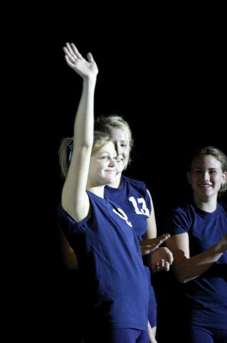 Tess (on the right) claps as the starters are introduced.